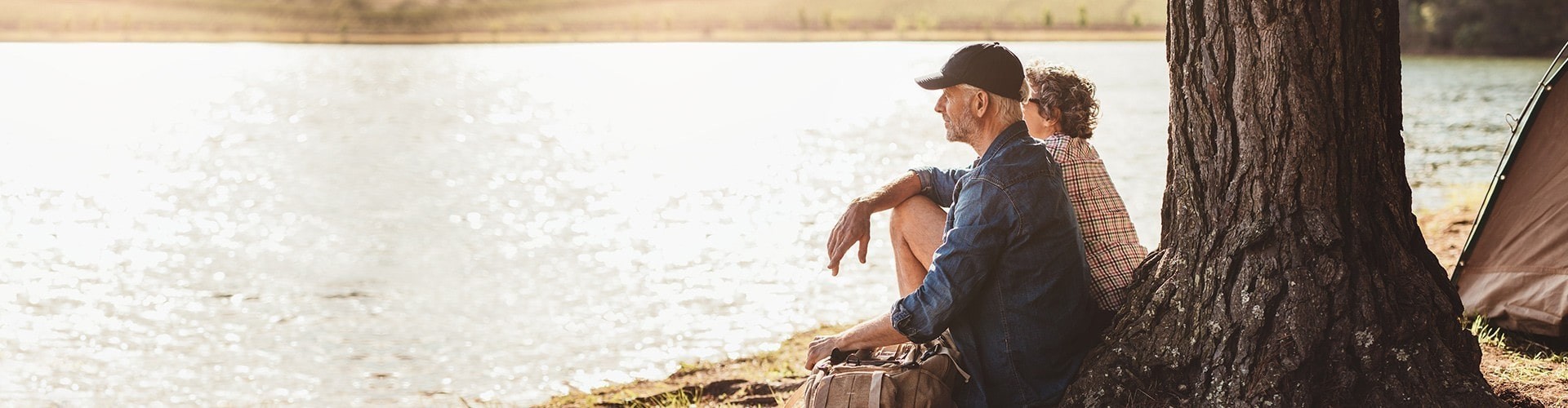 senior couple enjoying the view of a beautiful lake at their campsite